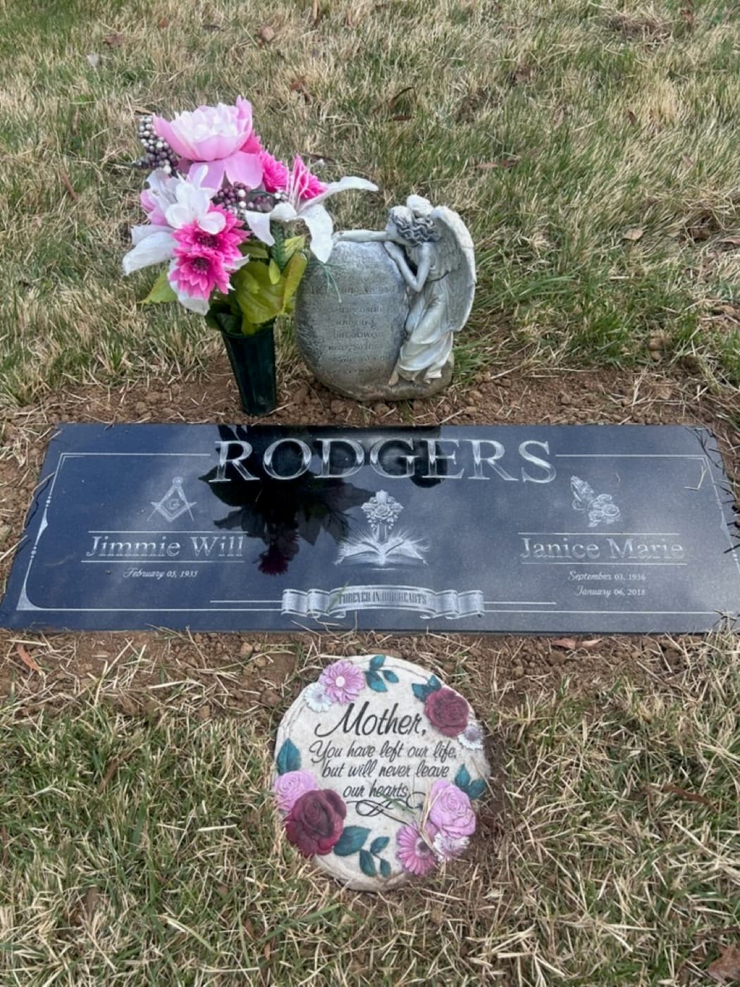 Companion flat marker for the Rodgers family — Masonic square, praying hands, cross, and open Bible engravings installed in a cemetery setting