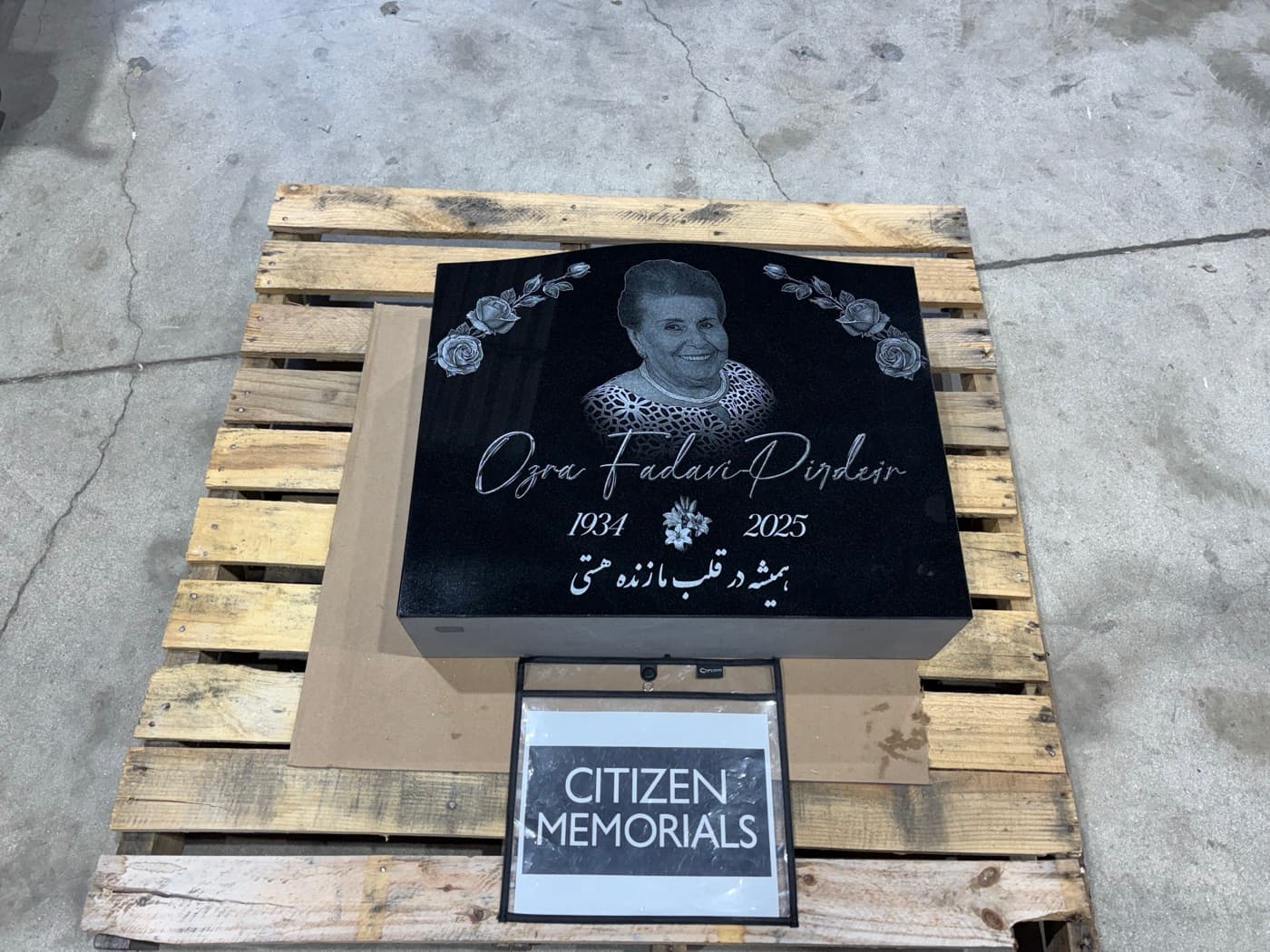 Flat grave marker for Ozra Fadavi-Pirdeir — laser-engraved portrait with Persian script epitaph and rose border detail on polished black granite